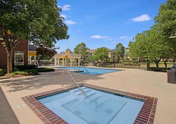 A swimming pool surrounded by a brick border with a diving board.