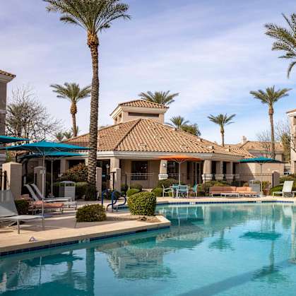 A large swimming pool surrounded by palm trees and lounge chairs.at Vintage at Scottsdale, SCOTTSDALE, 85260