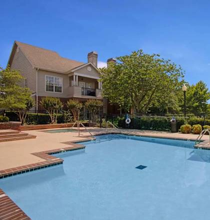 A large swimming pool in front of a house.