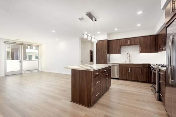 A modern kitchen with wooden cabinets and stainless steel appliances. at Elements Apartments*, Irvine