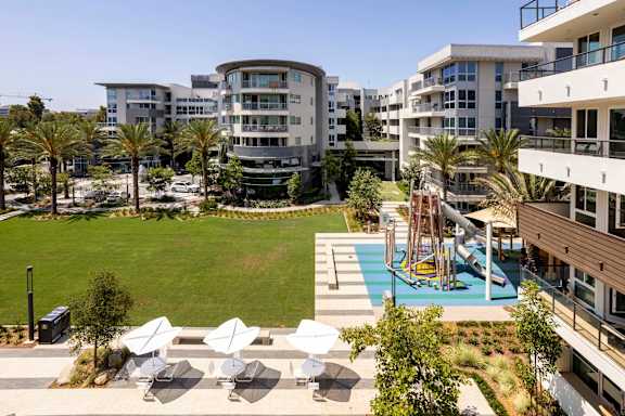 A modern apartment complex with a pool and playground. at Elements Apartments*, Irvine, 92612