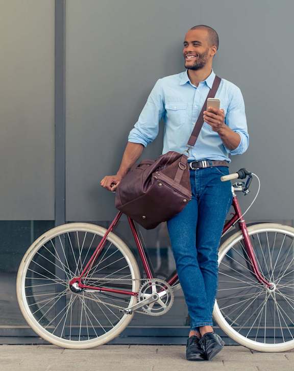 A man is standing next to a bicycle holding a phone at Northridge Gardens Apartments, Northridge