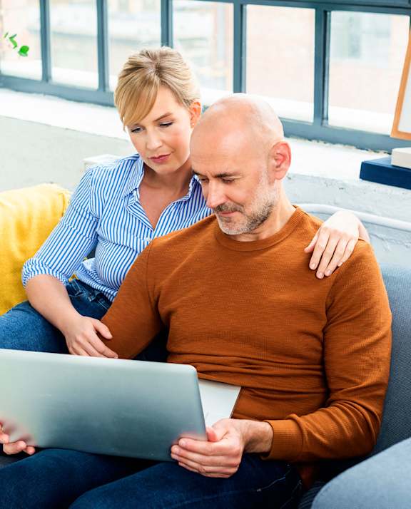 A man and woman are sitting on a couch with a laptop.at Fish Creek, Iowa