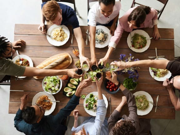 a group of people sitting around a table eating food