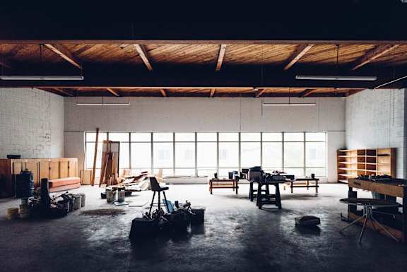A large, empty room with wooden beams and windows.