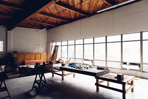 A room with a workbench and a chair in it.