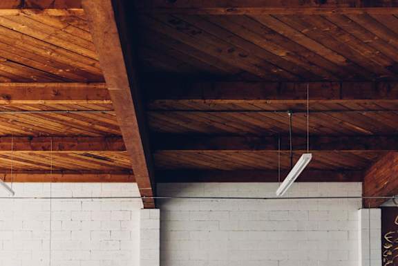 A white brick wall with a wooden beam on top.