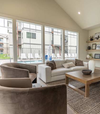 A living room with a fireplace and a flat screen TV mounted on the wall at Marcola Apartment Homes, Forest Grove, Oregon