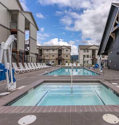 A swimming pool in a residential area with a blue chair at Marcola Apartment Homes, Oregon