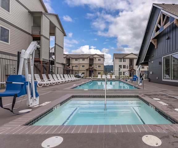 A swimming pool in a residential area with a blue chair at Marcola Apartment Homes, Oregon