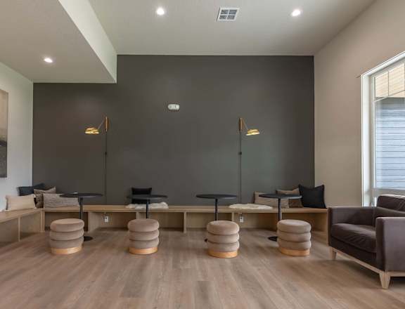 A living room with a grey couch, a wooden table, and a large painting on the wall at Marcola Apartment Homes, Forest Grove