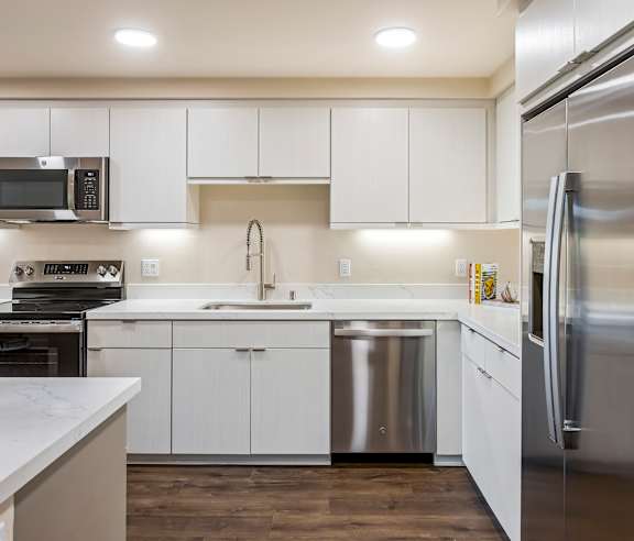 A modern kitchen with white cabinets and stainless steel appliances. at Casa Mira View Apartments, San Diego, CA 92126
