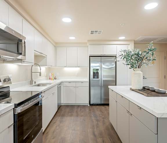 A modern kitchen with white cabinets and stainless steel appliances. at Casa Mira View Apartments, San Diego, CA 92126