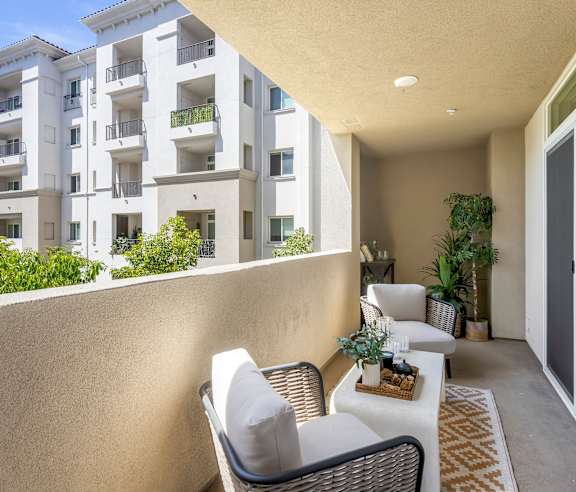 A patio with a table and chairs overlooks a building. at Casa Mira View Apartments, San Diego, CA 92126