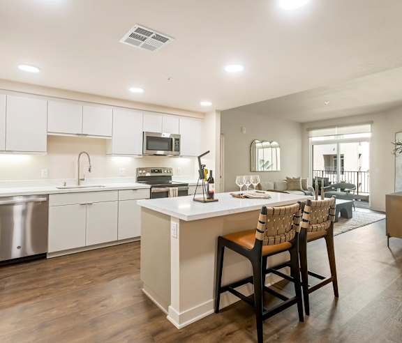 A modern kitchen with a large island and bar stools. at Casa Mira View Apartments, San Diego, CA 92126