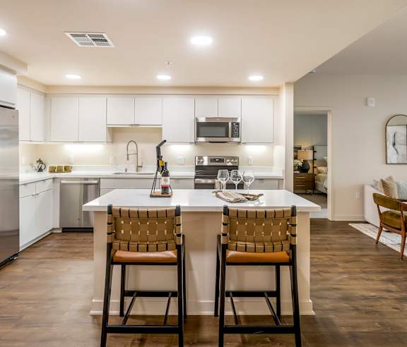 A modern kitchen with white cabinets and a center island. at Casa Mira View Apartments, San Diego, CA 92126