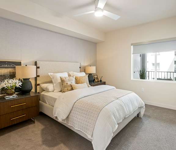 A bedroom with a large bed and a window. at Casa Mira View Apartments, San Diego, CA 92126