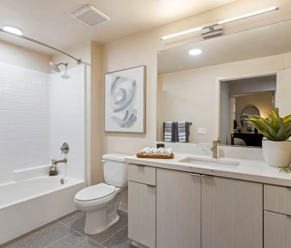 A modern bathroom with a white toilet, a white sink, and a white bathtub. at Casa Mira View Apartments, San Diego, CA 92126