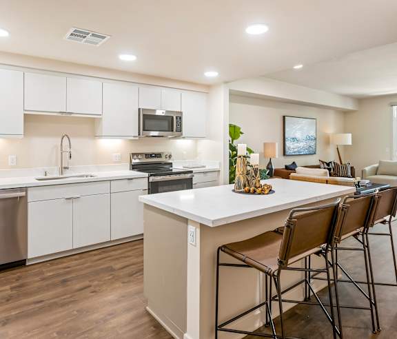 A modern kitchen with white cabinets and a large island. at Casa Mira View Apartments, San Diego, CA 92126