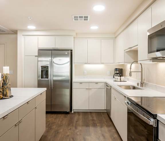 A modern kitchen with white cabinets and stainless steel appliances. at Casa Mira View Apartments, San Diego, CA 92126