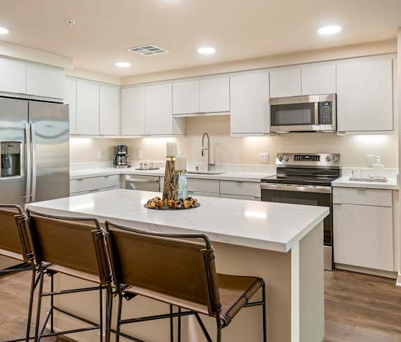 A modern kitchen with white cabinets and a central island. at Casa Mira View Apartments, San Diego, CA 92126