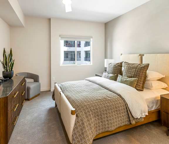A bedroom with a large bed and a window. at Casa Mira View Apartments, San Diego, CA 92126