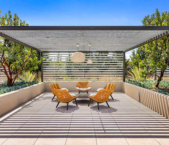 A patio with a table and chairs is covered by a roof. at Casa Mira View Apartments, San Diego, CA 92126