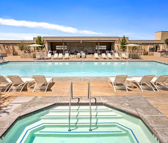 A pool with a diving board and lounge chairs. at Casa Mira View Apartments, San Diego, CA 92126