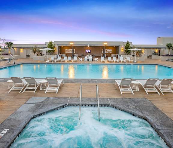 A large outdoor swimming pool with a hot tub and lounge chairs. at Casa Mira View Apartments, San Diego, CA 92126