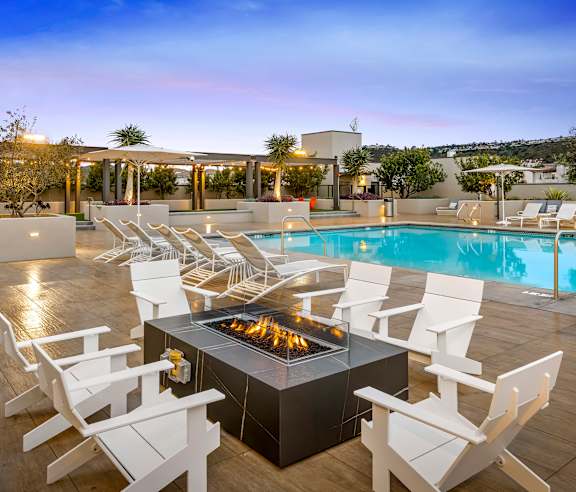 A modern outdoor seating area with a fire pit and chairs. at Casa Mira View Apartments, San Diego, CA 92126