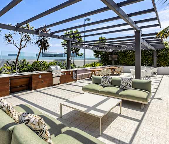 A patio with a green couch and a white coffee table. at Elements Apartments, Irvine, CA