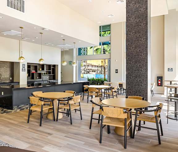 A modern dining area with wooden tables and chairs. at Elements Apartments, Irvine, CA