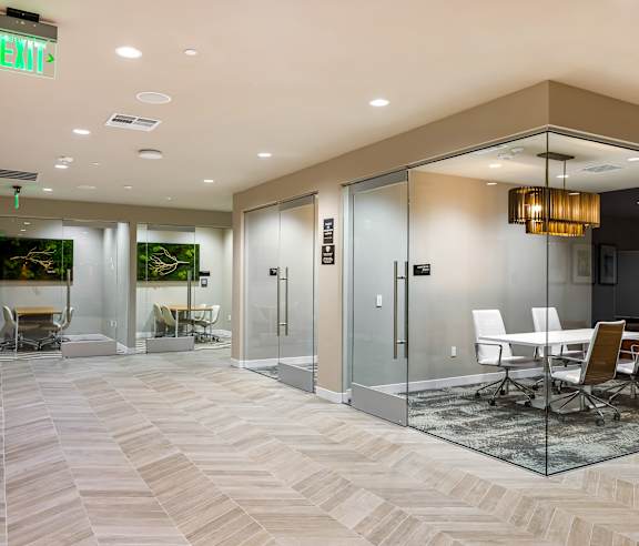 A conference room with glass walls and a white table. at Elements Apartments, Irvine, CA