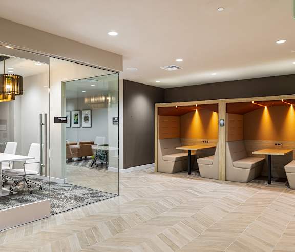 A modern office space with a glass wall and wooden flooring. at Elements Apartments, Irvine, CA