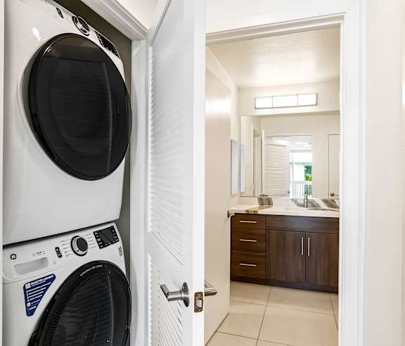 A white washing machine is in a doorway. at Elements Apartments, Irvine, CA