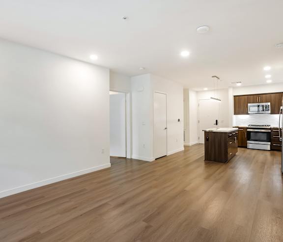 A kitchen with white walls and wooden floors. at Elements Apartments, Irvine, CA