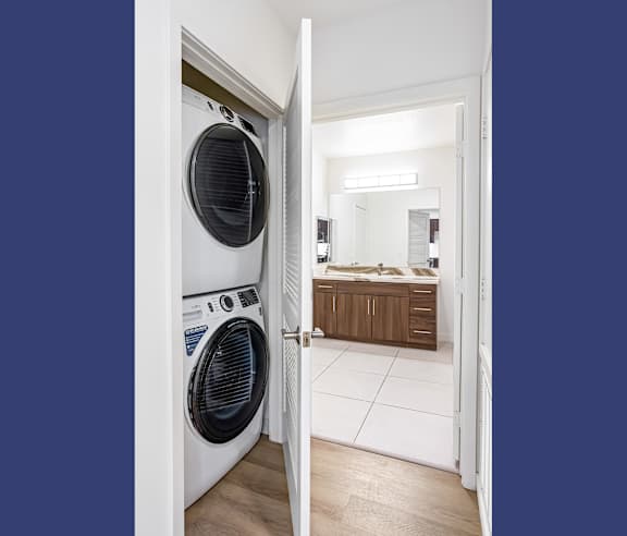 A white washing machine is in a doorway. at Elements Apartments, Irvine, CA