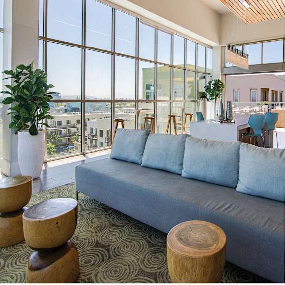 a living room with a blue couch and large windows