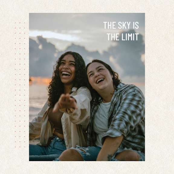 Two people sitting on the ground, one pointing forward.
