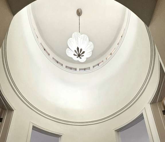 A spiral staircase with a chandelier hanging from the ceiling.