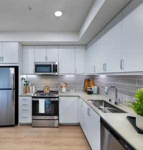a kitchen with white cabinets and a stainless steel refrigerator