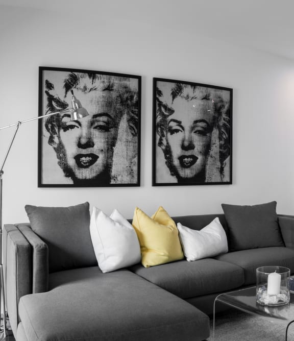 a living area with a couch coffee table and a kitchen in the background