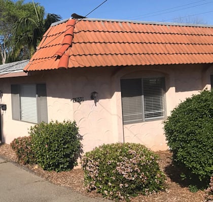 a house with a red tile roof and a black car parked in front of it