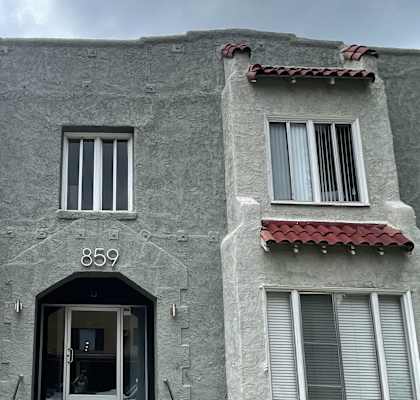 a gray building with windows and a door