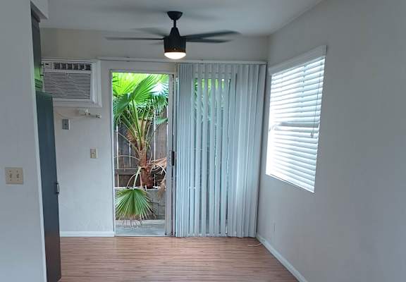 a room with a ceiling fan and a door leading to a patio