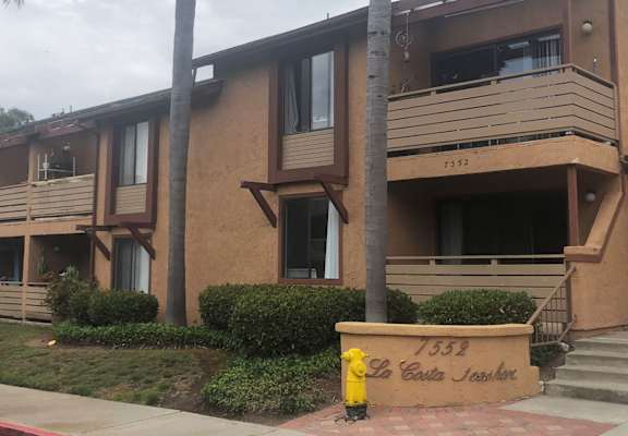 an apartment building with a yellow fire hydrant in front of it