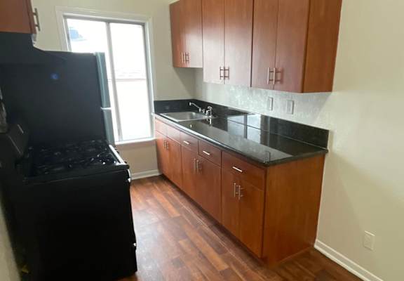 a kitchen with wooden cabinets and a black stove top oven
