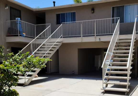 an apartment building with two sets of stairs in front of it