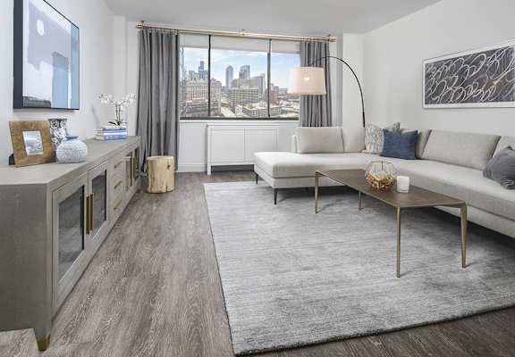 A modern living room with a large window overlooking the city.