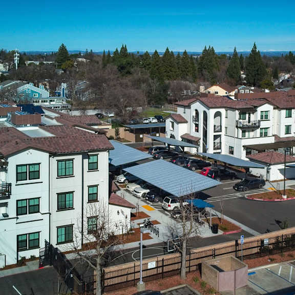 The front of the Mesa Vista Apartments building with a flag flying in the background.